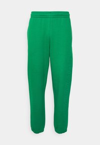  Grønne sweatpants med elastisk talje, tætsiddende afslutninger og et hævet logo langs siden. Fremstillet af blødt, struktureret materiale.