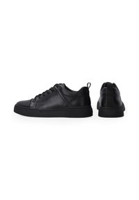 Schwarze Leder-Sneaker mit einem niedrigen Design, runder Zehenpartie und strukturiertem Gummisohle. verfügt über eine Schnürung und eine Schlaufe hinten.