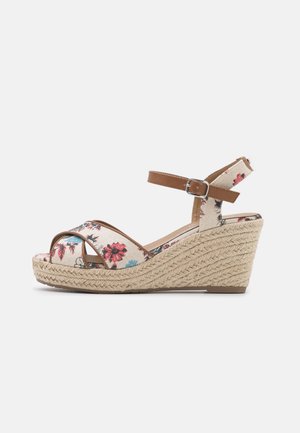 Sandale compensée avec plateforme tressée beige, brides en tissu fleuri et sangle de cheville en cuir brun, présentée de côté sur fond blanc.