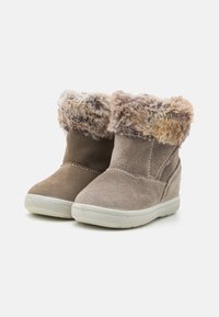 Bottines en daim marron avec un revers en fausse fourrure, des détails texturés et une semelle en caoutchouc blanc. Elles disposent d'un talon compensé et d'accents cousus.