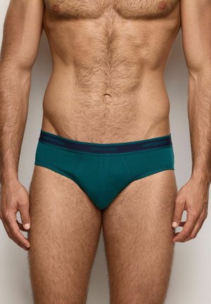 Türkise Herrenunterwäsche mit einem marineblauen Taillenbund, auf dem die Marke "yamamay" zu sehen ist. Das Material wirkt glatt und elastisch, ausgelegt für hohen Tragekomfort.