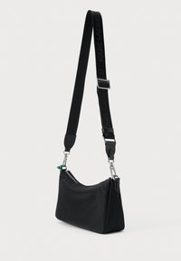 Borsa a tracolla nera in nylon con forma strutturata, chiusura a zip e tracolla regolabile con il nome del marchio. Include dettagli in hardware silver.