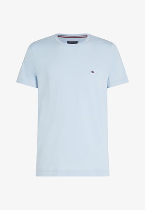 Világoskék pamut póló kerek nyakkivágással, rövid ujjakkal és egy kis logóval a mellkason. Vékony, sima anyagú, klasszikus szabású.