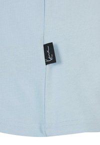 Hele sinine puuvillane T-särk musta sildiga külgedel. Omab pehmet tekstuuri ja puhtaid õmblusi põhjapealne ja külgõmblustes.