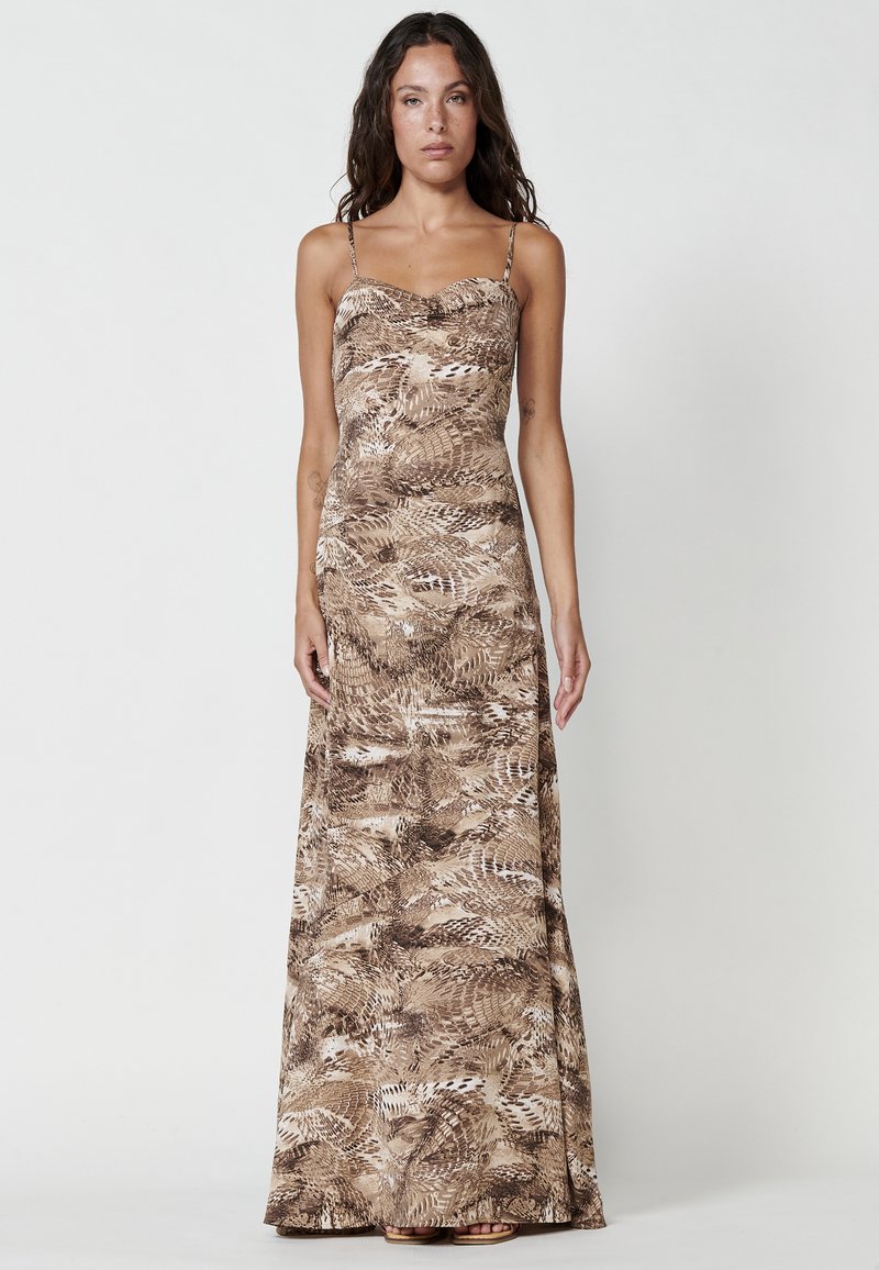 Brown maxi dress with spaghetti straps, featuring a fern pattern. Smooth fabric with a fitted bodice and flowing skirt.