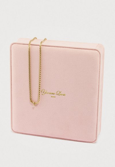 Boîte à bijoux en velours rose avec un collier à chaîne en or. Le collier présente un design torsadé et un petit pendentif, affiché à côté de la boîte.