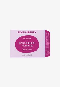 Różowe opakowanie kapsułek w kremie z bakuchiolem z fioletowymi akcentami, z wyraźnie widoczną nazwą produktu. Pojemność 50ml/1,69 fl. oz., klarowna marka.
