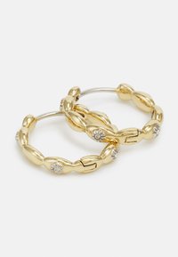 Boucles d'oreilles créoles en ton or avec un design en chaîne torsadée, dotées de petites accents en argent et d'une fermeture à clapet pour un port sécurisé.