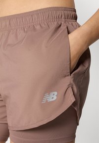 Shorts de sport lavande courts avec une finition texturée, dotés d'une taille élastique et d'une poche latérale. Comprend un accent logo réfléchissant.