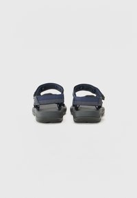 Marine sandaler med sorte gummisåler, med justerbart stroppdesign og teksturerte detaljer på de øvre stroppene for en sikker passform.
