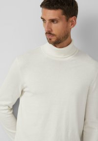 Weißer Rollkragenpullover aus weichem, strukturiertem Stoff. Verfügt über ein figurbetontes Design mit hohem Kragen und langen Ärmeln.