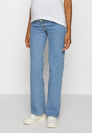 Jeans de ganga azul claros com um design de perna reta, apresentando um fecho de botão e zipper, e detalhes de costura mínimos. Usados com ténis brancos.