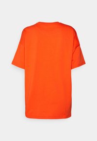 Lys orange T-shirt med korte ærmer set fra ryggen med rund halsudskæring og løs, afslappet pasform på en ensfarvet baggrund.