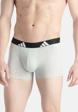 Boxer-briefs en coton gris avec une ceinture noire ornée du logo adidas blanc. Texture lisse et coupe ajustée pour le confort.