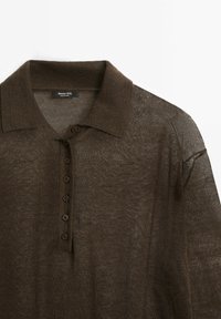 Braunes, kurzärmliges, gestricktes Poloshirt mit Kragen und sechs braunen Knöpfen auf der Vorderseite, das eine leichte, durchsichtige Textur aufweist.