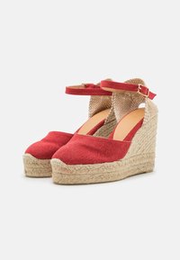 Červené plátěné wedge boty s tkaným jute podpatkem. Nártový pásek se zlatou sponou a texturovaným béžovým podšívkou. Kulatý tvar špičky.