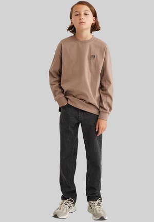 Een bruine katoenen sweatshirt met lange mouwen en een klein logo. Gepaarde met donkergrijze jeans en neutraalgekleurde sneakers. Eenvoudig ontwerp, casual pasvorm.