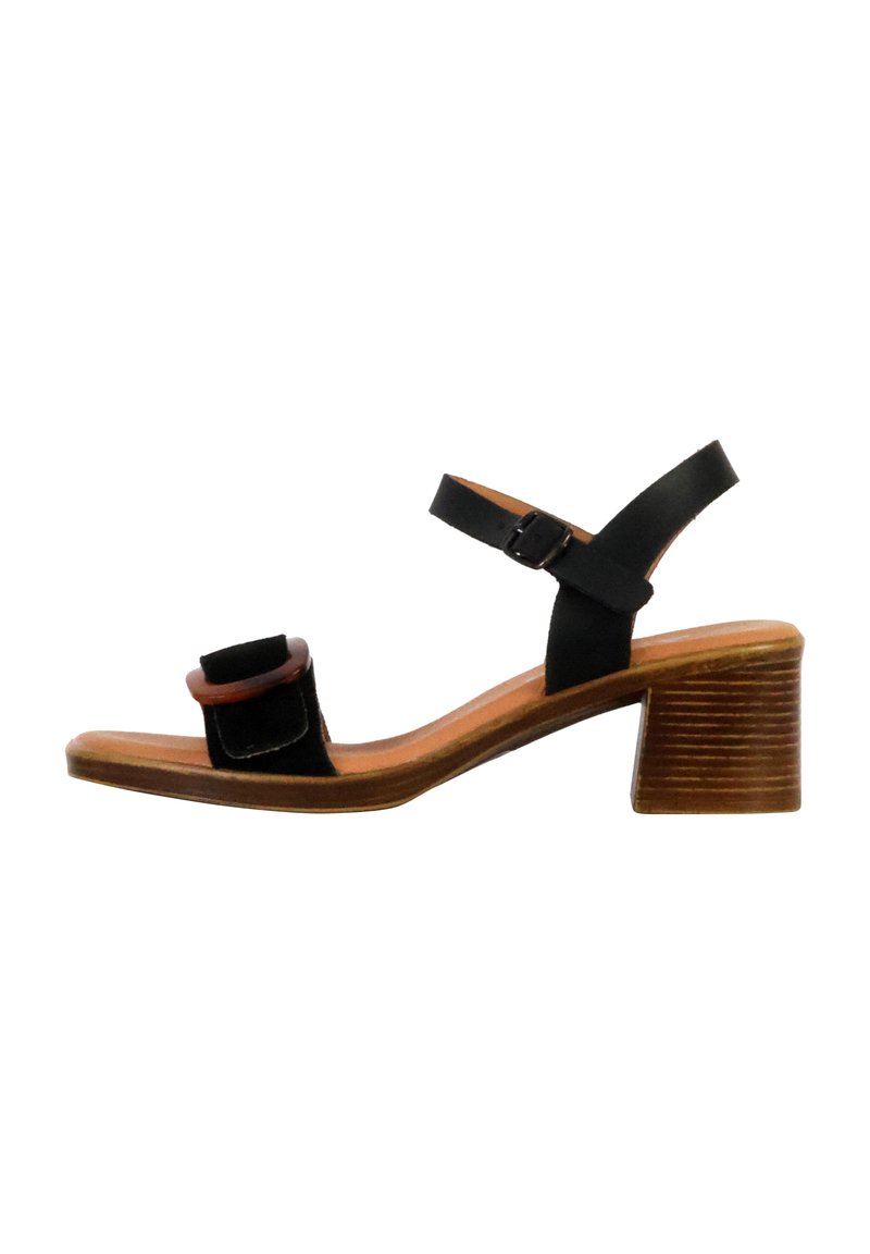 Schwarze Sandale mit einem breiten Riemen und einer quadratischen Schnalle. Verfügt über einen braunen Holzblockabsatz mit horizontalen Rillen. Obermaterial und Sohle aus Leder.