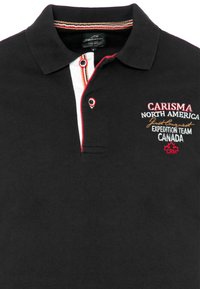 Sort polo skjorte med en stribet krave, med en hvid stolpe, røde detaljer og broderet tekst: "Carisma North America Expedition Team Canada."