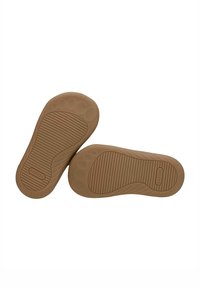 Suole in gomma color sabbia con superficie texture, caratterizzate da righe e un motivo circolare. Il nome del marchio "BARTEK" è visibile su una suola.