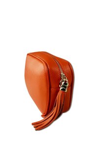 Orange leather cosmetic bag with a rectangular shape, gold zipper, and tassel detail, showing a textured surface.