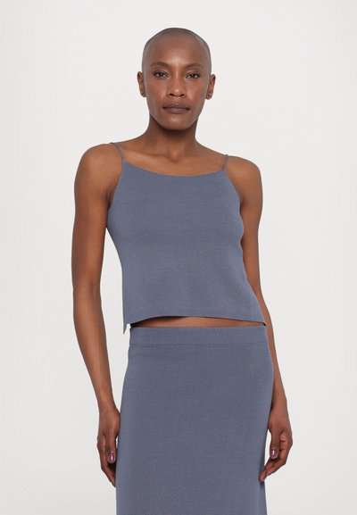Blaues geripptes Strick-Crop-Top mit dünnen Trägern. Hat ein tailliertes Design und einen geraden Saum, kombiniert mit einem passenden Rock. Glatte Textur über das gesamte Material.