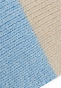Knitted fabric features a diagonal split with soft blue and beige colors, showcasing a textured pattern and smooth finish.