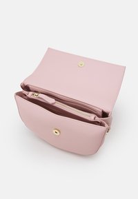 Clutch in pelle rosa chiaro aperto per mostrare due scomparti, uno con una cerniera dorata e una chiusura a scatto.