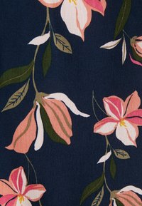 Tissu bleu foncé avec un motif floral mettant en vedette des fleurs roses et blanches ainsi que des feuilles vertes et beiges sur de fines tiges marron.