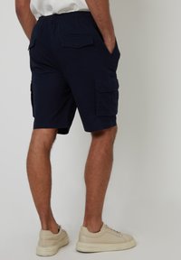 Marineblaue Cargo-Shorts mit elastischem Bund, Seitentaschen und zwei großen Klapptaschen. Aus leichtem Stoff und tailliertem Schnitt gefertigt.