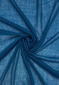 Niebieski len ułożony w spiralny wzór, charakteryzujący się jasnym, lekko teksturowanym splotem o półprzezroczystej jakości.