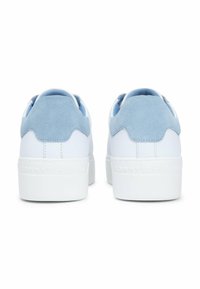 Sneakers bianche con un morbido accento in suede blu sul tallone, suola in gomma texture e branding discreto sul retro, che mostrano un design a profilo basso.