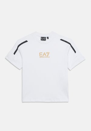T-shirt blanc à manches courtes avec des bandes noires aux épaules et le logo doré EA7 Emporio Armani centré sur la poitrine.