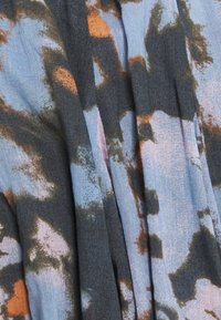 Mönstrad tyg i blå, grå och orange nyanser med abstrakta former. Mjuk textur, lätt skrynklig, med en blandning av färger och mönster.