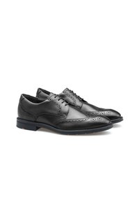 Chaussures habillées en cuir noir avec un design à bout golf, perforations brogue, et une semelle en caoutchouc contrastée. Texture lisse avec une fermeture classique à lacets.