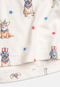 White fabric featuring a repeated pattern of dogs in festive attire, wearing sunglasses and party hats, with red and blue stars scattered throughout.