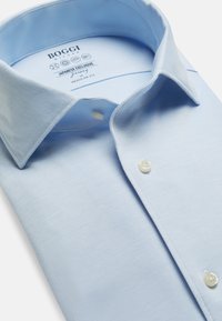 Svetlomodrá košeľa s golierom vyrobená z bavlny, s klasickým strihom, zapínaním na gombíky vpredu a bielymi gombíkmi s jemnou štruktúrou.