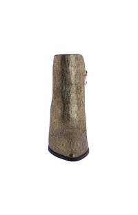 Botín metálico dorado hasta el tobillo con rayas texturizadas, cierre de cremallera lateral y punta afilada. Presenta un acabado liso similar al cuero y suela negra.