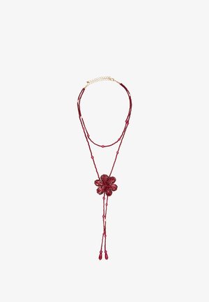Dobbeltrådet rødt perlekæde med en blomstformet perle som midterstykke og to hængende tråde, der ender i dråbeformede perler.