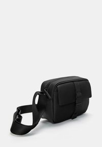 Borsa a tracolla rettangolare nera in materiale sintetico strutturato, con chiusura a zip, pattina frontale e tracolla regolabile.