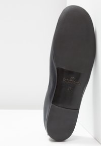 Semelle de chaussure en cuir noir avec texture lisse. Gravée des mots "COPENHAGEN" et de la taille "37". Forme arrondie, design minimaliste.