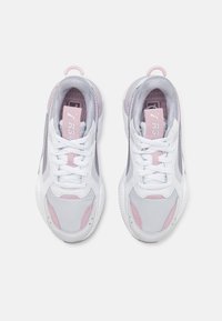 Zapatillas deportivas con parte superior de malla en blanco, gris y acentos en rosa claro. Presentan cordones, cuello acolchado y suela texturizada. Diseño ligero.