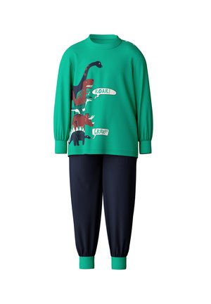 Sweatshirt vert avec des graphiques de dinosaures et les phrases "GRRRR !" et "ROAR !", associé à un pantalon bleu marine avec des poignets verts.