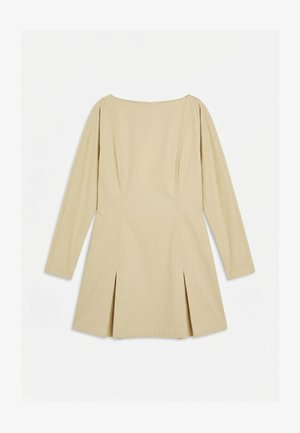 Pitkähihainen beige mekko veneaukkokauluksella, sauman yksityiskohdilla ja edessä laskostuksilla, esitettynä tasaisena valkoisella taustalla.