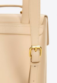 Beżowy skórzany pasek torebki z złotą metalową klamrą, z estetycznym przeszyciem i gładką teksturą. Prosty, ustrukturyzowany design.