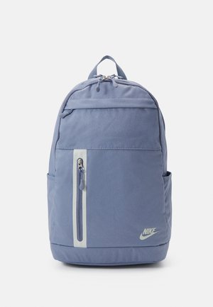 Sac à dos Nike bleu clair avec poche zippée verticale à l'avant, poignée supérieure, poches latérales et compartiment principal zippé sur fond blanc.