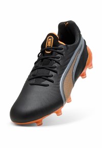 Svarte fotballsko med oransje detaljer, med en teksturert overdel, mesh-tunge og mønstrede sidelogoer. Studdet gummisåle.