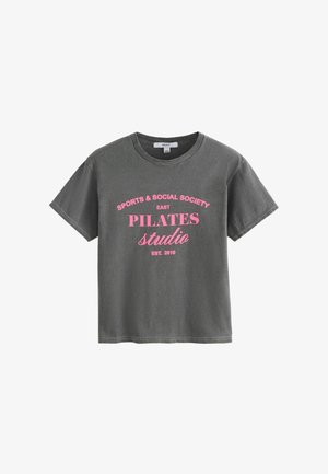 Sötétszürke rövid ujjú póló rózsaszín felirattal elöl: "SPORTS & SOCIAL SOCIETY EAST PILATES studio EST. 2010".