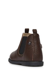 Hnědé kožené kotníkové boty s elastickými bočními panely, texturovaným povrchem, poutky pro snadné obutí a kulatou špičkou. Vybavené černou gumovou podrážkou.