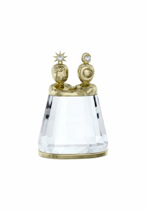 Kristallfigur med två guldfärgade gestalter med detaljerade ansikten, en prydd med en solsymbol och den andra med en måne, som vilar på en fasetterad bas.